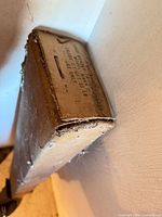 Close-up of end of screen housing showing worn cardboard cover and partial printed label