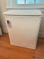 Front view of white woven resin wicker hamper closed