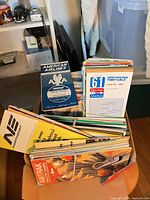Box of assorted transit timetables and maps from airlines, bus and rail services