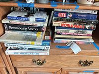 Two stacks of hardcover and paperback history books on shelf