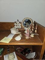Entire group on shelf showing mirror, sailboats, ornament, shells