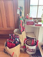 Wrapping paper rolls and gift bags in shopping bags beside boxed cards