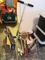 Group shot showing both scooters, two wooden rackets and leather skates