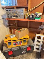 Overall lot showing black and yellow toolboxes, parts organizer and cardboard box