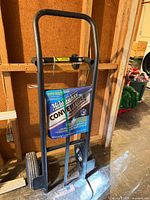 Front view of the Milwaukee convertible hand truck showing frame, handle, base plate, and attached packaging