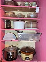 Shelving with bowls, covers, mugs, glassware, appliances and utensil bin