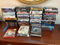 Full lot on dresser showing stacked discs and front-row CDs and PS3 game
