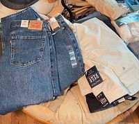 Stack of Levi’s jeans and Nautica khaki chinos with visible tags