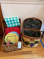 Both wicker baskets, one open showing grape fabric lining and tableware inside