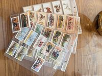 Stack of plastic binder pages holding vintage cigarette cards of various themes