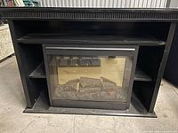 Front view of black mantel with electric fireplace insert and shelves