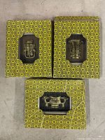 Three patterned boxes showing metal carvings through cutouts