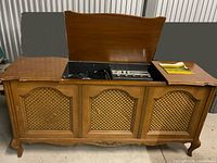 Closed wooden console stereo showing three lattice doors and lid open