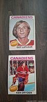 Front view of Guy Lafleur and Ken Dryden O-Pee-Chee cards showing player images, team name and positions