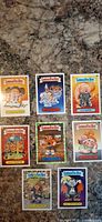 Eight Garbage Pail Kids cards laid out on countertop