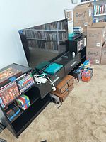 Front view of black engineered wood TV stand with shelves and drawers