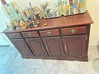 Front view of dark cherry sideboard showing three drawers and four doors