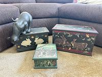 Group shot of three rabbit boxes and black cat figurine