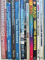 Spine view of twelve books showing mix of genres and formats