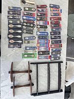 Full lot overview showing packaged souvenir spoons and wooden display racks