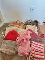 Group shot of all nine crochet and woven bags laid out on carpet