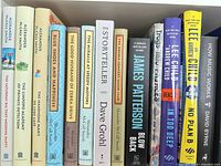 Shelf view showing Alexander McCall Smith novels, Dave Grohl memoir, James Patterson thriller, Lee Child title and David Byrne nonfiction