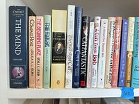 Shelf showing a selection of animal, cat, reference, and fiction books including Oxford Companion to the Mind, several Ursula K. Le Guin titles, Alexander Hamilton biography, Catfantastic and Bob series books