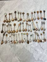 All spoons laid out in five rows on marble surface