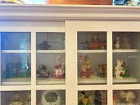 Cabinet view showing multiple rabbit figurines across shelves