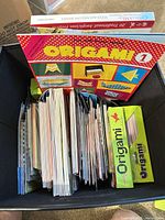 Bin with Origami 1 book and stacks of paper packs