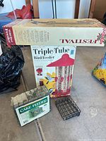 All four items: boxed Triple Tube feeder, boxed Festival feeder, wrapped cake feeder, loose suet cage