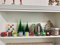 Shelf view showing glass trees, ornament tree, foam stamp blocks, CDs, metal trivet, tin