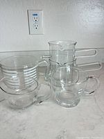 All five glass pitchers and creamers grouped on countertop