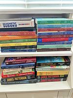 Full view of shelves showing approximately 23 books and Magnetic Sudoku game