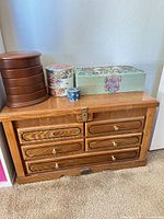 All five items: oak jewelry chest, brown round organizer, floral porcelain stackable boxes, blue trinket jar, fabric-covered jewelry box