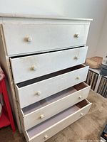 Front view showing five drawers and knobs