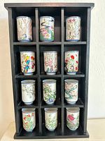 Front view of rack holding 12 porcelain tumblers