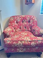 Front view of red floral tufted armchair