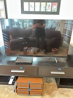Front view of Samsung TV on stand with Blu-ray player beneath