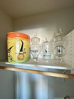 Group shot showing metal Halloween tin and three labeled glass jars