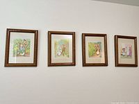 Four framed prints mounted on wall showing relative size and frame style