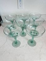 Six of the eight seafoam green margarita glasses displayed in two rows