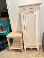 Side table next to tall white cabinet