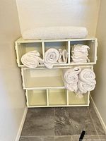 Front view of stacked cubby shelf with towels in and on it