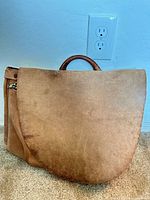 Front view of tan leather flap-over satchel