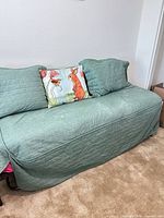 Daybed assembled with green quilted coverlet and pillows
