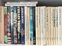 Front view of spines showing variety of travel and nature titles and overall condition