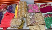 Overview of assorted Indian garments and scarves on table