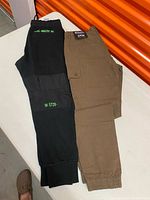 Both pairs of trousers side by side on table