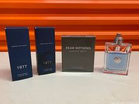 Lot overview showing three boxed American Eagle colognes and Versace spray bottle